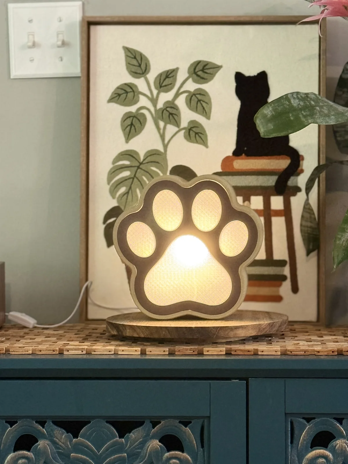 Anonymous custom print job example showing a 3D printed paw-shaped light-up lamp in a room display.